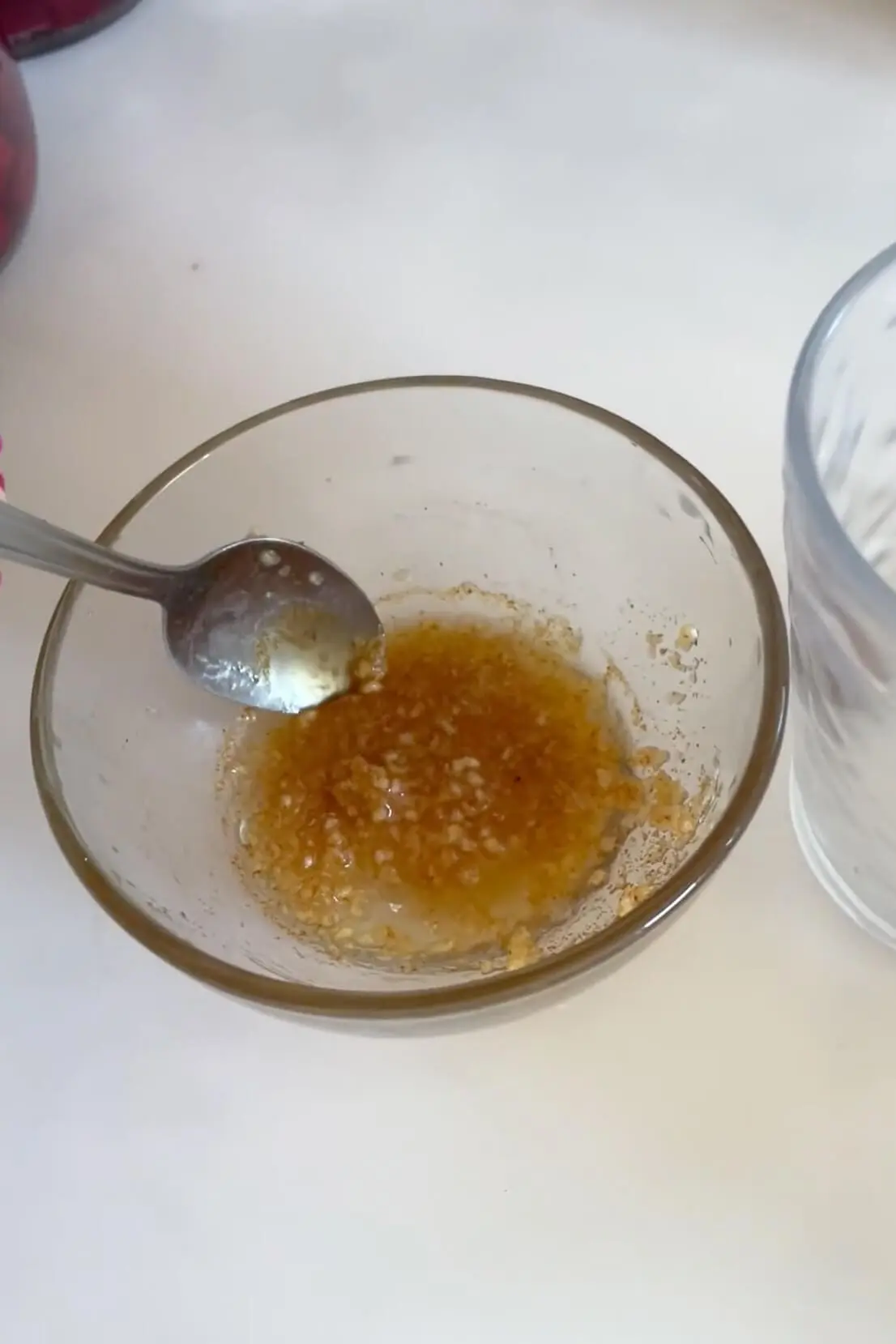 Close-up of mixed honey and garlic in a glass bowl, a potent DIY home remedy for sore throat relief.